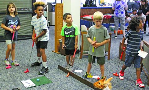 Sentinel photo/Jessica Shepard Children of all ages tried their luck with mini golf at the Bay City Public Library, Monday, June 13. The event was sponsored by the Friends of the Bay City Public Library and also featured food trucks and other games. 