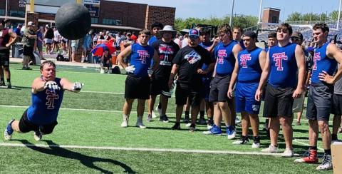 Photo  courtesy of Deeana Sneath Tidehaven’s Clyde Griffith puts his effort into a kneeling medicine ball throw at the Lineman Challenge.