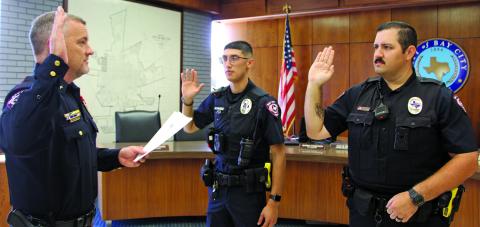 Sentinel Photo/Mike Reddell Bay City Police Chief Robert Lister swears in two new officers, John Alvarez, center, and Charles Coombs during a swearing-in ceremony July 6 at City Hall.