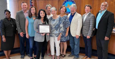 Sentinel photo/Jessica Shepard Bay City Main Street Program Manager Tina Israel, center, is joined by board members Fran Baker and Jennifer Bishop, while showing off the Main Street America Program and Texas Main Street Accreditation certification as a Main Street America program for meeting rigorous performance standards during the regular city council meeting on July 26. Israel told council the award was based on 2021 work and events downtown.