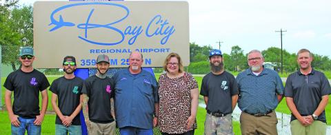 Sentinel Photo/Jessica Shepard Marking the recent completion of the new Bay City Regional Airport frontage sign on FM 2540 were, from left: Chase Meyers, Austin Gardiner, Stew Savage, all three with Savage Fab; Airport Manager James Mason; City Manager Shawna Burkhart; Savage Fab owner Chris Savage; Tourism Director Darve Smith; and City Council Member Blayne Finley.