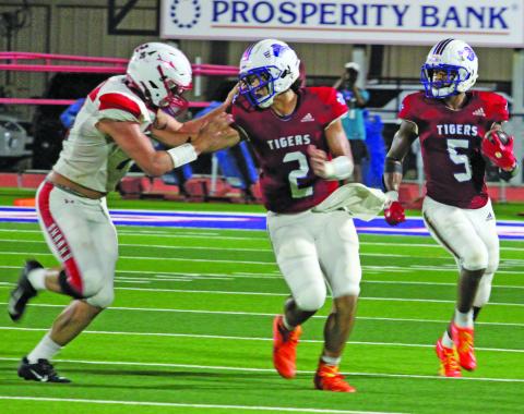 Sentinel Photo/Jessica Shepard Tidehaven quarterback Jachen Duran (2) blocks a Shark defender that gives Tiger running back Joseph Dodds (5) more room to run.