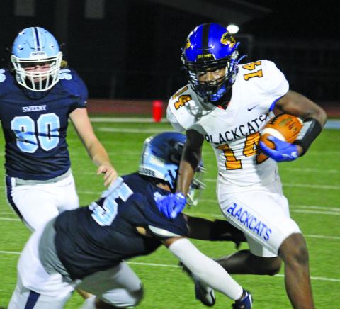 Sentinel Photo/Mike Reddell Blackcat running back Paris Fox (14) gets around two Sweeny defenders to pick up yards.