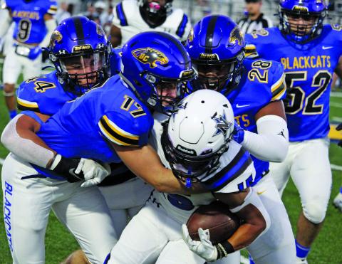 Sentinel Photo/Mike Reddell Blackcat senior linebacker Blake MacLennan (17) ties up a Navasota running back with the help of Elijah Suarez (44) and Karius Luster (28).