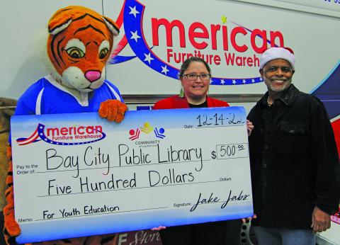 American Furniture Warehouse presented a $500 check to Bay City Public Library during the Bay City Regional Airport’s recent events around Santa’s airport visit. Shown are, from left: The Warehouse mascot, Lbrary Director Samantha Denbow and Bay City Mayor Robert Nelson. Sentinel Photo/Mike Reddell
