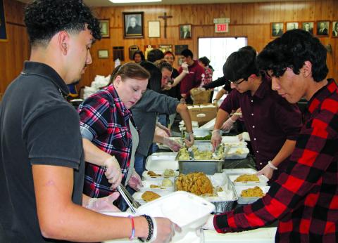 Sentinel Photo/Mike Reddell A team of volunteers helps prepare chicken fried steak dinners for the Crisis Center fundraiser at the Knights of Columbus Hall Friday, Jan. 20..