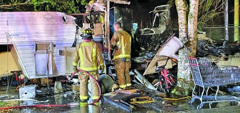 Photo by Dan Shook Firefighters examine damage from this trailer fire at 2517 Nichols Street March 19. 