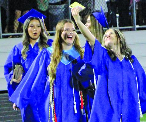 Sentinel Photo/Jessica Shepard Several Bay City High School graduates took time to snap a few selfies with their friends before throwing their mortarboard caps.
