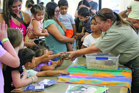 Sentinel Photo/Jessica Shepard Animal Control Officer Dotty Grandstaff discussed animal safety for wild and domestic animals during the Bay City Public Library's "Tales & Tails" event Monday, July 3. Grandstaff also allowed children to pet rescued turtles, tortoises, and her own dog, Mia.
