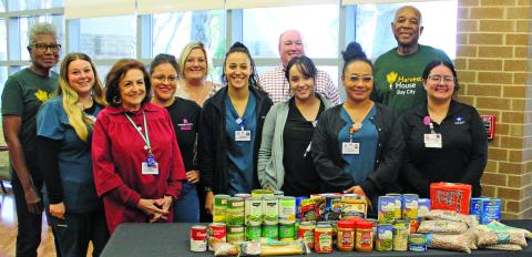 Sentinel Photo/Jessica Shepard Matagorda Regional Medical Center staff poses with a variety of non-perishable food and hygiene donations with Harvest House Volunteers Nov. 15. The hospital is hosting a food drive for donations to the local food pantry until Dec. 15.