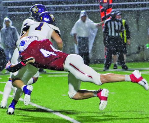 LeDarion Stone/Live in the Moment Photography Tidehaven defensive End Justin Griffith (44) makes a diving tackle on a Buffalo running back in the driving rain.