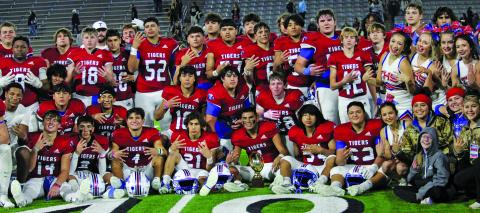 Photo by Anna Hernandez Tidehaven players, coaches, cheerleaders and trainers gather for a group photo of the Tigers winning the regional semi-finals trophy.