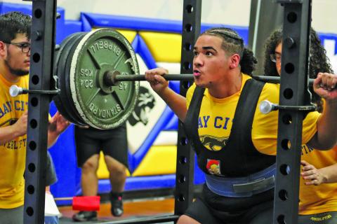 LeDarion Stone/Live in the Moment Photography Above Blackcat strains at performing the squat at BCHS Powerlifting Tournament Saturday, Jan. 13.