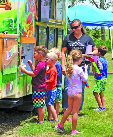 Sentinel Photo/Jessica Shepard Free snow cones were just a part of the summertime fun at El Maton National Hall last week. The Wednesday, July 31, event featured water slides, a water-filled volleyball court, bubble machine, snacks, water balloons, and a train ride for kids of all ages. Attendees also registered for a chance to win several door prizes including gift buckets and various inflatable toys.  