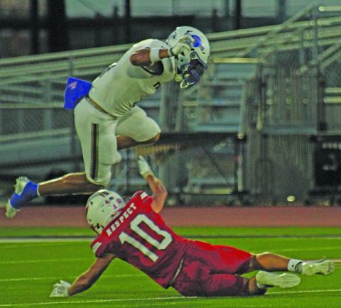 Photo by Anna Hernandez Tidehaven’s Boogie Galvan (4) hurtles over Palacios defender Noah West (10).