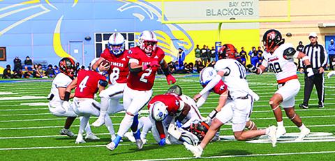 Sentinel Photo/Jessica Shepard Tiger back Jachen Duran (2) leads the blocking for quarterback Kale Russell (8) against Van Vleck last Friday. The onlookers behind them are BCHS students, who will later board buses for their quarferfinal game in Converse.