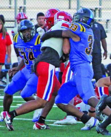 Sentinel Photo/Mike Reddell Blackcat defensive end Jordan O’Neal (33) wraps up a Brazosport Exporter, while freshman defensive tackle Kelon Ellis (34) moves in to help.