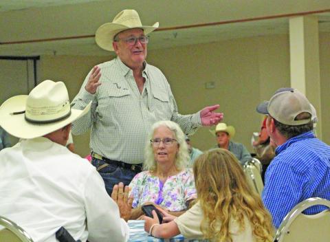 Sentinel Photo/Jessica Shepard Matagorda County Cattlemen's Association member George Harrison, standing, talks with several attendees at the MCCA's "New World Screwworm Seminar" on Thursday, June 25.