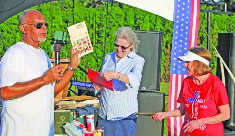 Sentinel Photo/Mike Reddell Bay City Mayor Robert Nelson holds up a 1976 phone book taken from the time capsule that he, Matagorda County Museum Director Cynthia Armstrong and Museum Archivist Jennifer Bishop opened earlier during ceremonies at the city’s LeTulle July 4 events.