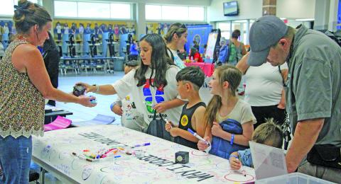 Sentinel Photo/Jessica Shepard Bay City ISD families participated in the district's annual "Back to School Bash" on Wednesday, July 29. While students were able to receive backpacks full of school supplies, guardians toured informational and community vendors at the Bay City High School campus. Other event features included health and dental screenings, games, prizes, bus rider information, and physicals with EKG testing.