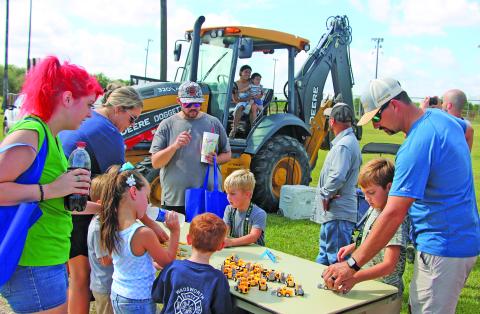 Sentinel Photo/Mike Reddell Parents and kids alike were drawn to the collection of tiny machines with a real backhoe loader as a background at the 7th Annual Touch-A-Truck Extravaganza Saturday, Sept. 12, at the Sports Complex. The event allowed kids to climb aboard giant trucks, explore heavy equipment, meet hometown heroes, and experience the thrill of sitting behind the wheel of real working vehicles - from towering CAT equipment to flashing emergency vehicles. 