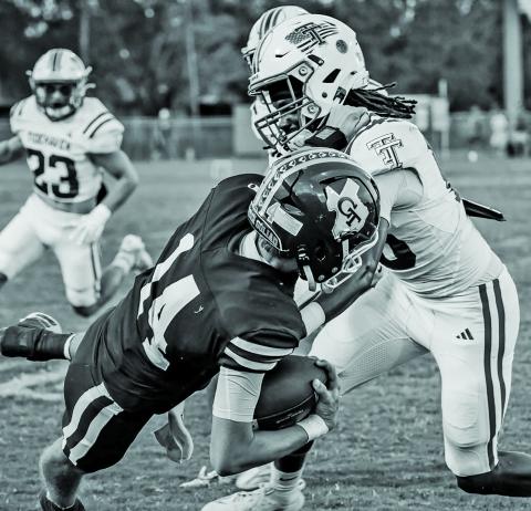 Migas Productions A Tidehaven defender topples a Goliad running back in last week’s game between the two teams.