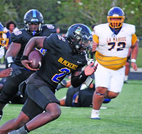 Sentinel Photo/Mike Reddell Above, Blackcat quarterback Keimarion Wiggins (2) breaks through La Marque defenders for large gain.