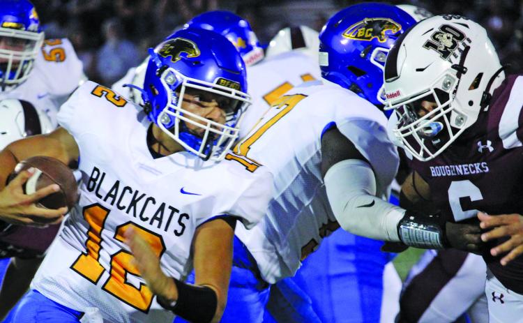Sentinel photo/Mike Reddell Blackcat quarterback Joel Davalos (12) battles for yardage against Columbia defenders.