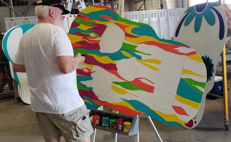 Sentinel photo/Jessica Shepard Local artist Rayleigh Conklin works on finishing up a groovy paint job on one of several large sugar skull displays for the "Day of the Dead" festival, Oct. 22. The festival is slated for noon to 10 p.m. Saturday, Nov. 6, at Le Tulle Park.
