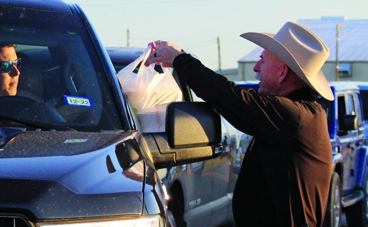 Sentinel photo/Jessica Shepard Precinct 1 Constable Doug Schoppe, right, hands out to-go plates as part of the Crisis Center's annual chicken fried steak fundraiser Jan. 21. Proceeds from the event help the center maintain its services to Matagorda and Wharton county residents.