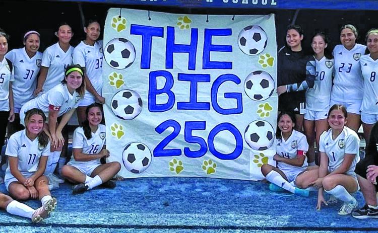 Contributed photo Ladycat Soccer members and Head Coach Darin Dobelgott show off banner proclaiming soccer program’s 250 win - since the girls started playing soccer - after defeating Sweeny there 4-0 Saturday, March 5, at Sweeny.