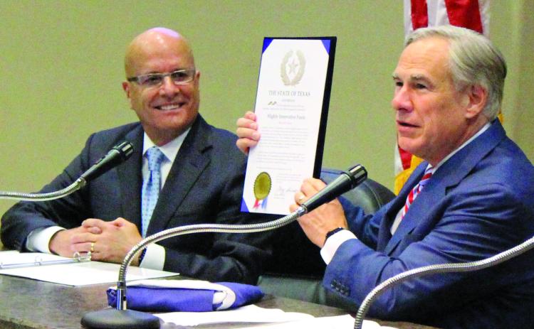 Sentinel photo/Jessica Shepard HIF Global CEO Renato Pereira (left) looks on approvingly as Gov. Greg Abbott presents a state proclamation recognizing HIF’s selection of Matagorda County for the nation’s first eFuel plant and a Texas flag flown over the capitol.