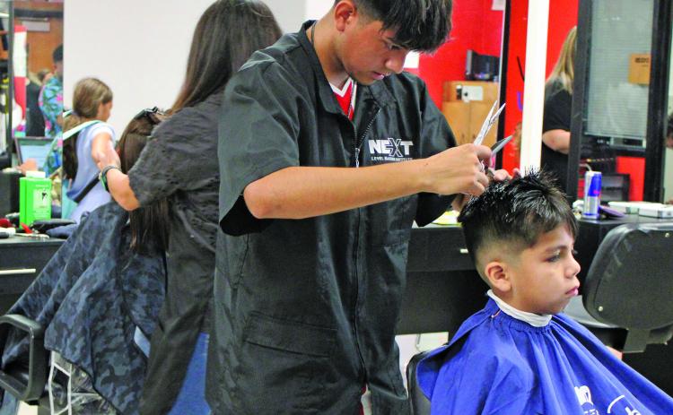 Sentinel photo/Jessica Shepard Local hairstylists and barbers provided free haircuts to Bay City ISD students during the district's "Back to School Bash" Thursday, Aug. 11. The stylists worked throughout the entire event for children of all ages.