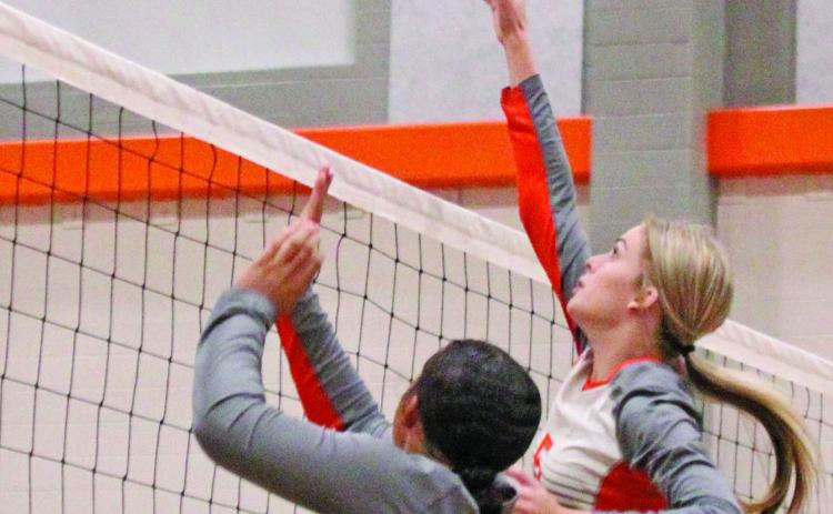 Van Vleck’s Ashlynn Winzenried (5) and Olivia Brittion (11) get the teamwork done during last week’s volleyball game against Bloomington.   Photo by  Anna Hernandez