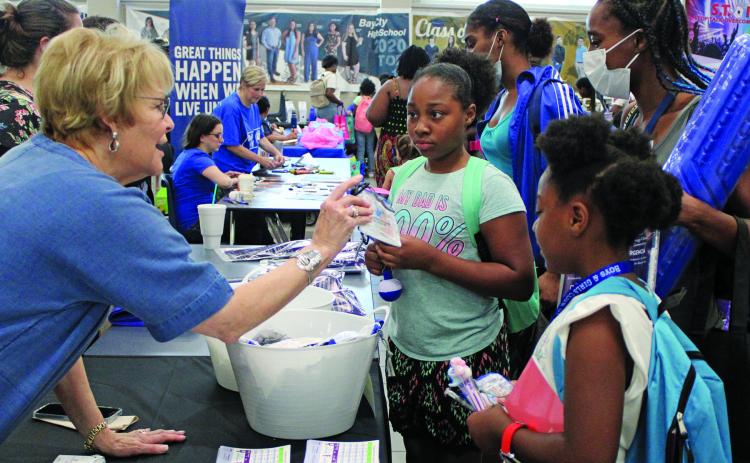 Sentinel Photo/Jessica Shepard Linda Allison, left, handed out treats for kids and information for Allison & Thompson Insurance Services for parents during Bay City ISD's "Back to School Bash" Thursday, Aug. 11. Allison's booth was among over 40 at the event.