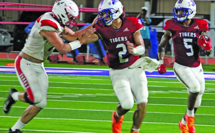 Sentinel Photo/Jessica Shepard Tidehaven quarterback Jachen Duran (2) blocks a Shark defender that gives Tiger running back Joseph Dodds (5) more room to run.