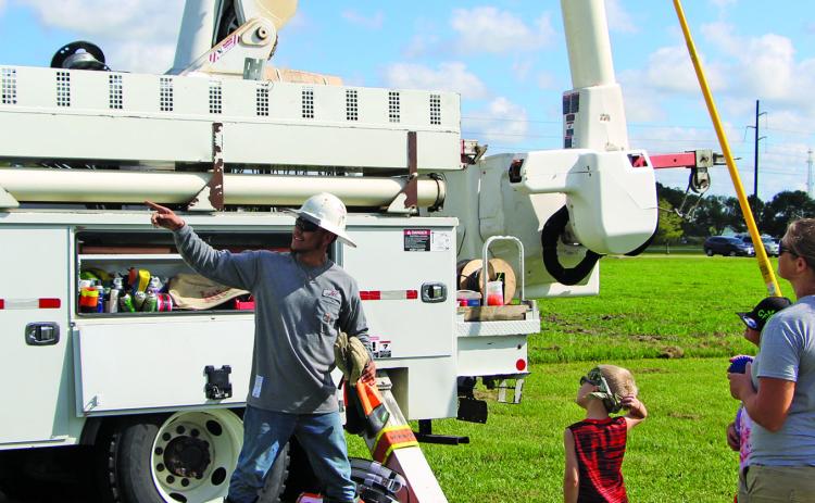 Sentinel photo/Mike Reddell A JEC employee explains how things work on a JEC utility bucket truck at the Touch a Truck event at Hardeman Park Saturday, Sept. 17. There was a good turnout at the Parks and Recreation Department event that also featured various equipment and work trucks.