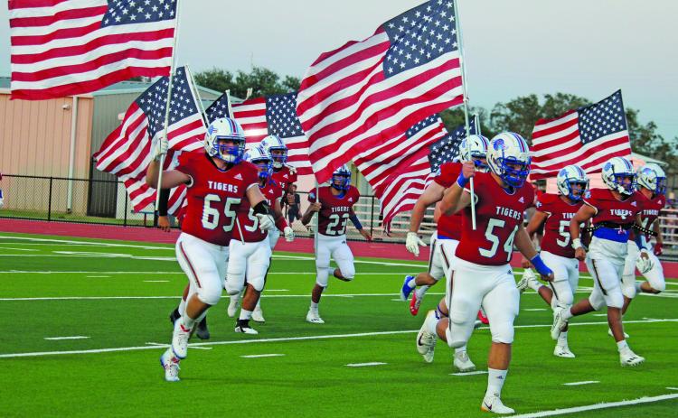 Sentinel photo/Jessica Shepard Tidehaven football players carry American flags as a 9/11 remembrance at last Friday’s Tidehaven-Palacios game. See related Tidehaven remembrance photo on Page 3.