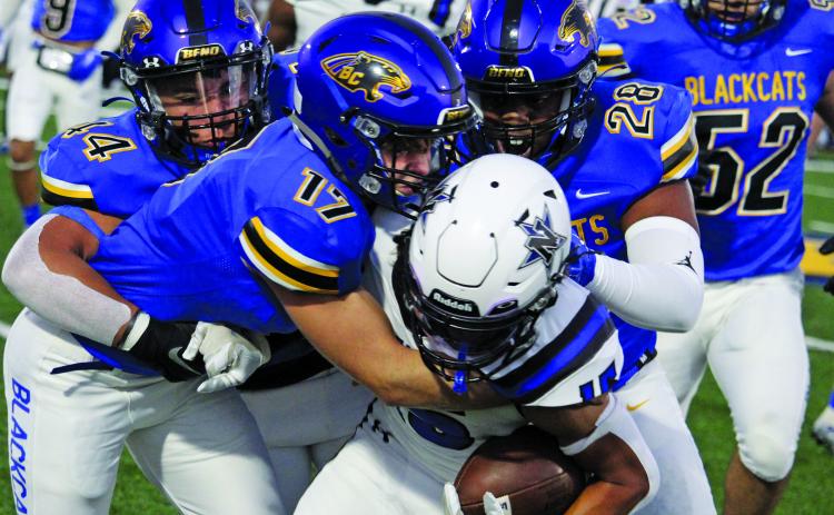 Sentinel Photo/Mike Reddell Blackcat senior linebacker Blake MacLennan (17) ties up a Navasota running back with the help of Elijah Suarez (44) and Karius Luster (28).