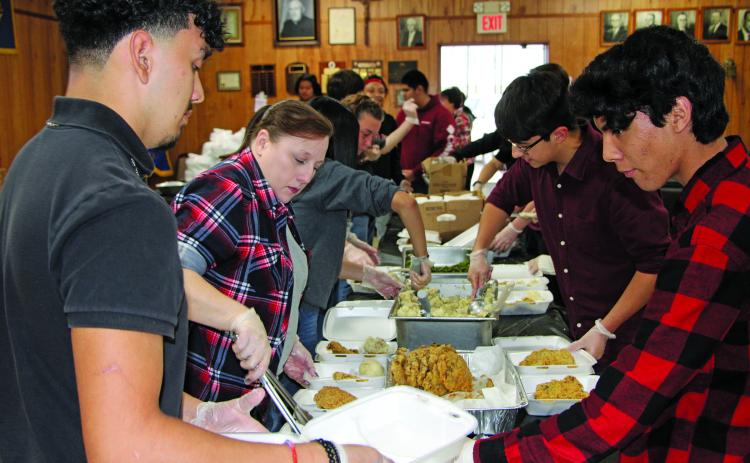 Sentinel Photo/Mike Reddell A team of volunteers helps prepare chicken fried steak dinners for the Crisis Center fundraiser at the Knights of Columbus Hall Friday, Jan. 20..