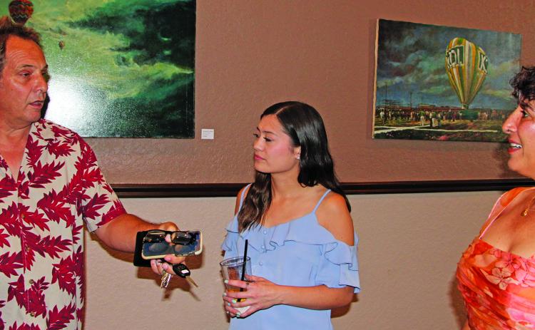 Sentinel Photo/Mike Reddell The Fat Grass Restaurant & Bar held an after-hours "Artist Reception" showcase of Gene Geeslin paintings Wednesday, June 28. Above, from left, are Stephen Logan, Christina Humphries and Zeinab Ghais.
