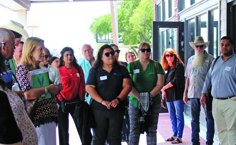 Sentinel Photo/Jessica Shepard Bay City Main Street Program Director Tina Isreal, right, explains how almost every downtown business has used the program’s façade grants to beautiful or renovate their building’s exteriors. Israel’s downtown walking tour was the capstone of the Houston-Galveston Area Council’s “Downtown Roundtable” July 25.