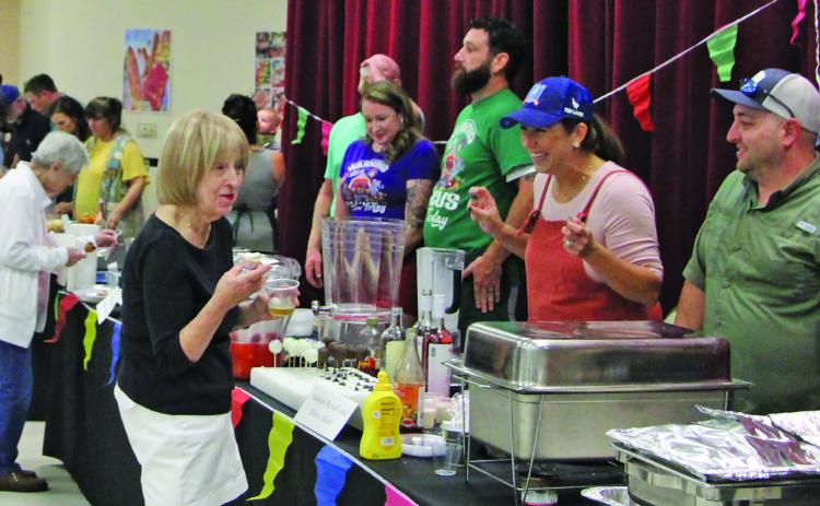 Sentinel file photo Connie Cornman visits with cooking team at last year’s Gourmet Guys.