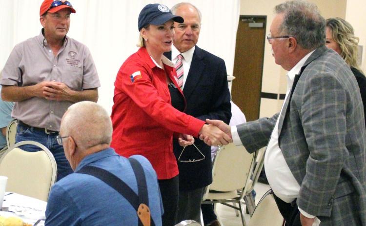 Sentinel Photo/Jessica Shepard Land Commissioner Dawn Buckingham shakes hands with MCEDC Executive Director Mike Ferdinand, while Precinct 2 Commissioner Mike Estlinbaum, left, and Chamber President Mitch Thames look on.