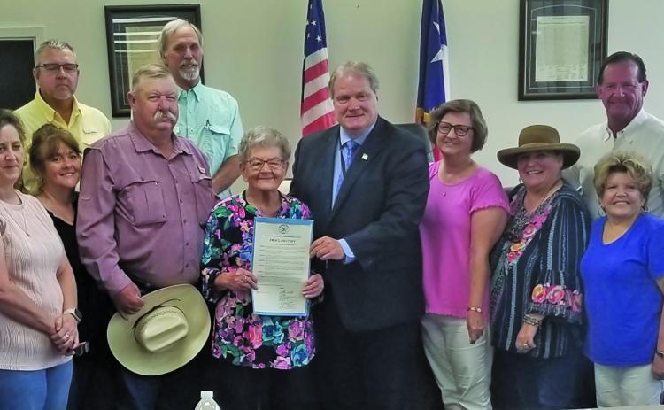 Sentinel Photo/Mike Reddell Commissioners Court proclaimed Monday, July 15, as Helen Feldhousen Day in Blessing. Miss Helen, center with proclamation from County Judge Bobby Seiferman, was joined by family and friends at the court session. She started as kitchen support in 1969 and became sole proprietor in 1977 and continued through 2024.