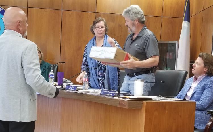 Sentinel Photo/Mike Reddell Bay City Police Narcotics Division Head Sgt. Joe Bruno, left, hands a shipment box with illegal drugs to, from left, Mayor Pro Tem Becca Sitz, and Councilmen Jim Folse and Bradley Westmoreland at a recent council meeting.