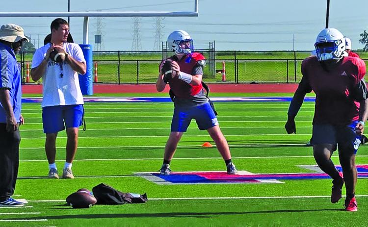 Sentinel photo/MaLinda Reddell New Tiger coach Bryce Galvan helps guide the Tidehaven passing drill.