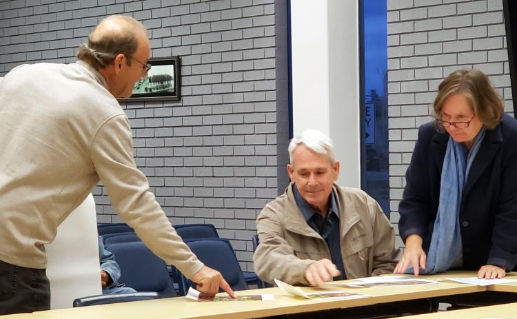 Sentinel photo/Jessica Shepard City Variance Committee members Bill Frontz and Becca Sitz, right, review artist Tom DeGroot's, left revised sign for the Neon Moon during a meeting Friday, Dec. 6.