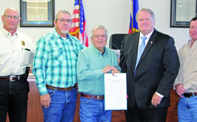 Sentinel Photo/Jessica Shepard Commissioners approved a resolution honoring outgoing Sheriff Frank “Skipper” Osborne, center, for his service to the county Monday morning. With Osborne are, from left: Sheriff Rick DeLeon, Precinct 4 Commissioner Bubba Frick, County Judge Bobby Seiferman, and Precinct 2 Commissioner Mike Estlinbaum.