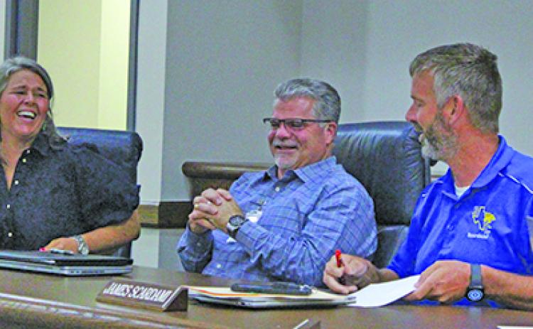 Sentinel Photo/Jessica Shepard New Bay City ISD Superintendent of Schools, Christopher Townsend, center, shared a laugh with BCISD Board President Jill Westmoreland, left, and Board Vice President James Scardami, right, June 10.